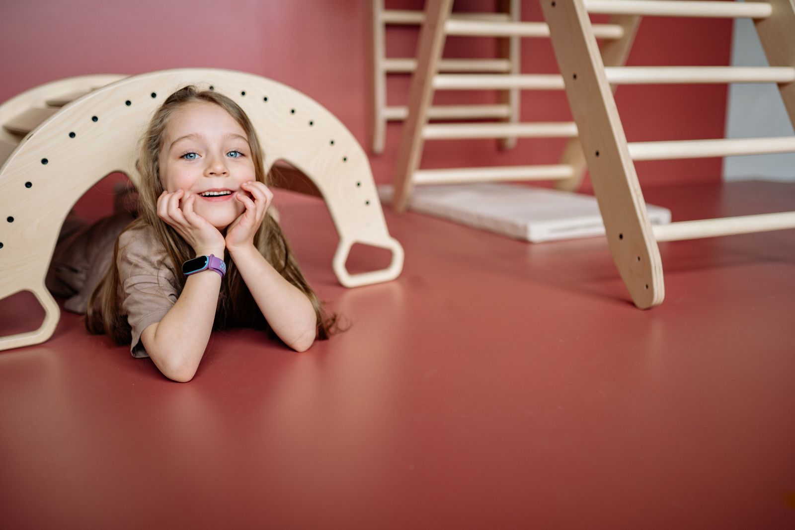 A child-friendly wooden play structure in a bright, open therapy space