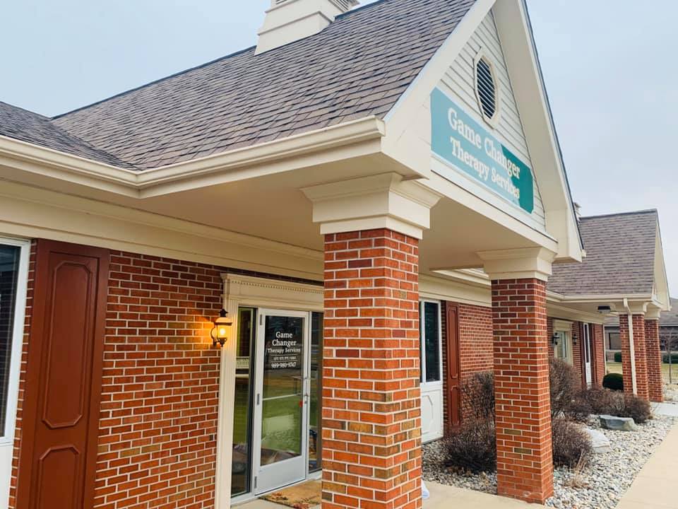 Brick clinic building with a covered entrance and Game Changer signage