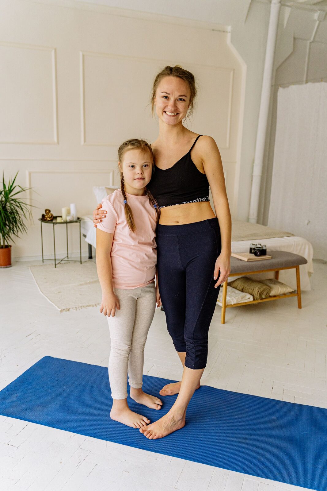 An adult and a child working one-on-one together on a floor mat
