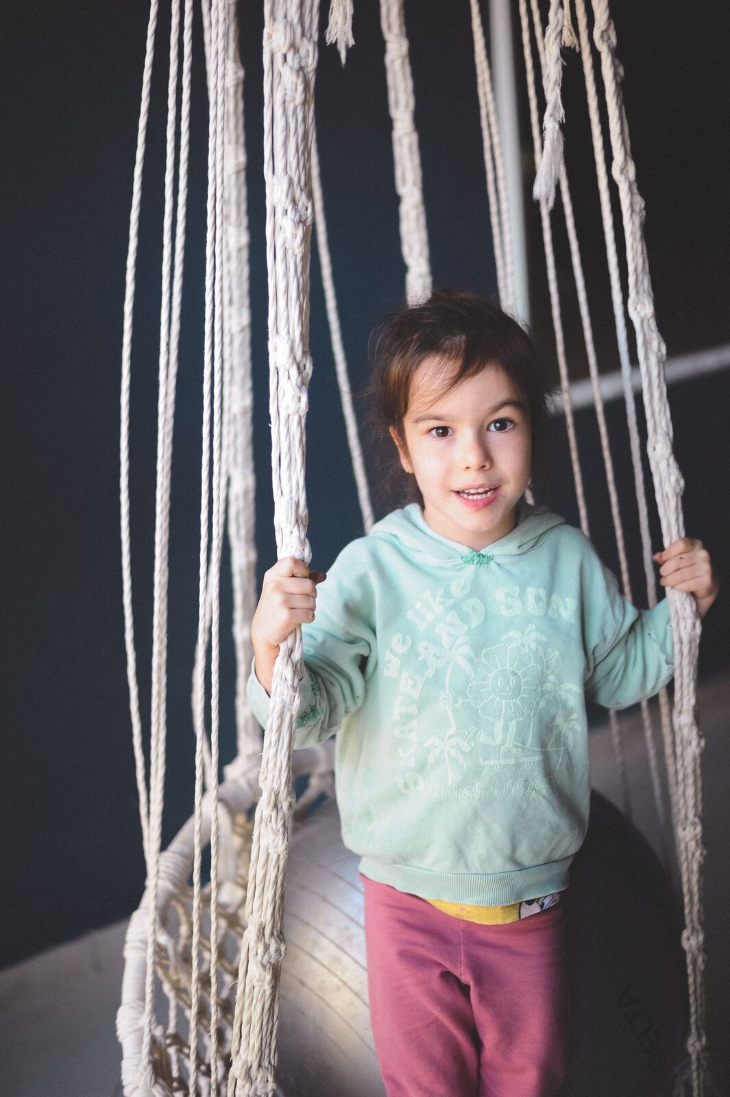 A child on an indoor therapy swing in a sensory gym